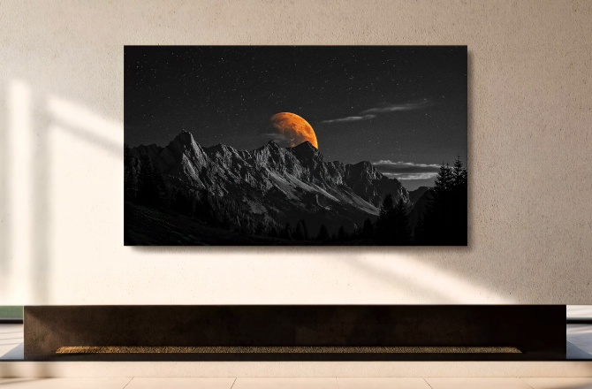 모던한 인테리어 벽면에 설치된 대형 OLED TV 화면 속 설산 위로 떠오른 커다란 붉은 달.
